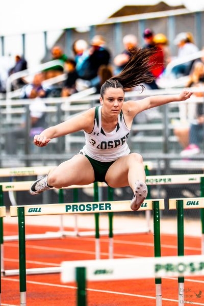Jumping over a hurdle, junior Riley Kincade focuses on the track. Kincade's primary position is contributing to the 100m High Hurdles team. Members of the Track & Field team competed at the UIL 6A Region 1 Championship from May 1-2 at the University of Texas at Arlington.