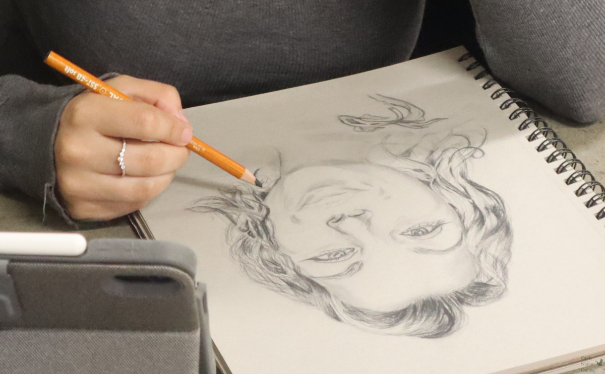 Sketching at a desk, Sapphire Vasquez works on a portrait. Sapphire Vasquez is a substitute teacher for art. "I've enjoyed (the different art) a lot because everybody has a different style, everybody wants different materials," Vasquez said. "They are creating things that they love on top of the things that they probably don't enjoy as much."
